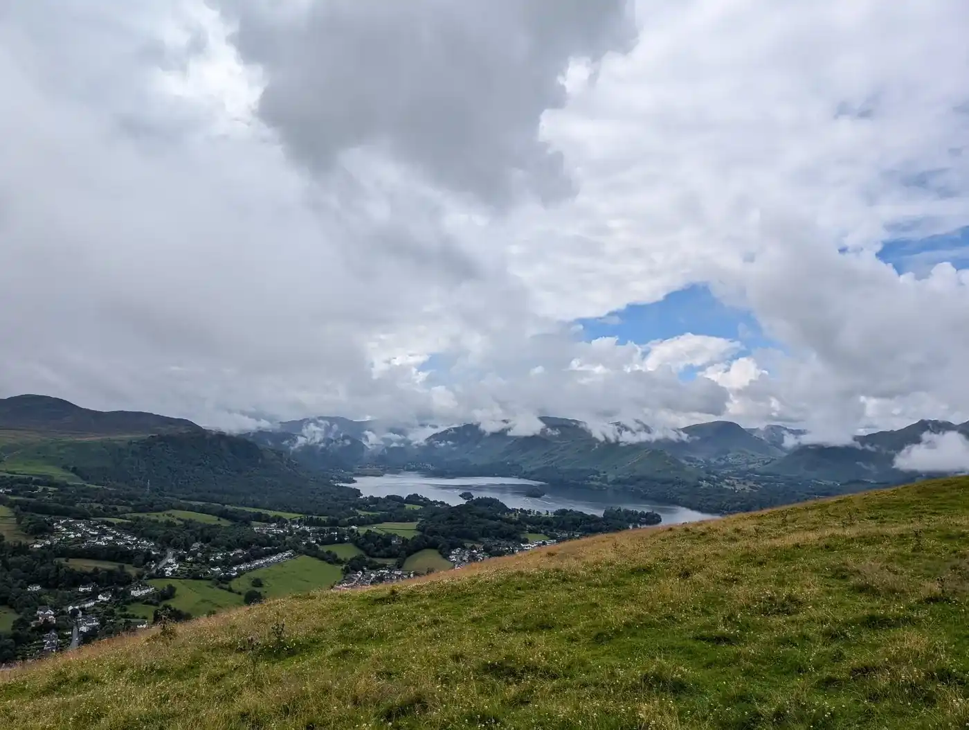 Latrigg - a grassy slope above Keswick and Derwentwater, cloud-draped fells ringing the lake beyond