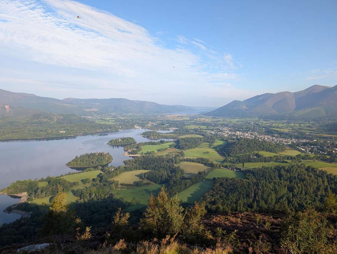 Walla Crag - a high view over Derwentwater and its wooded islands to Keswick and Skiddaw, fields glowing in evening light