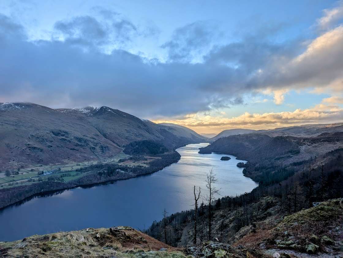 Thirlmere reservoir ringed by conifer plantation, the Helvellyn ridge beyond