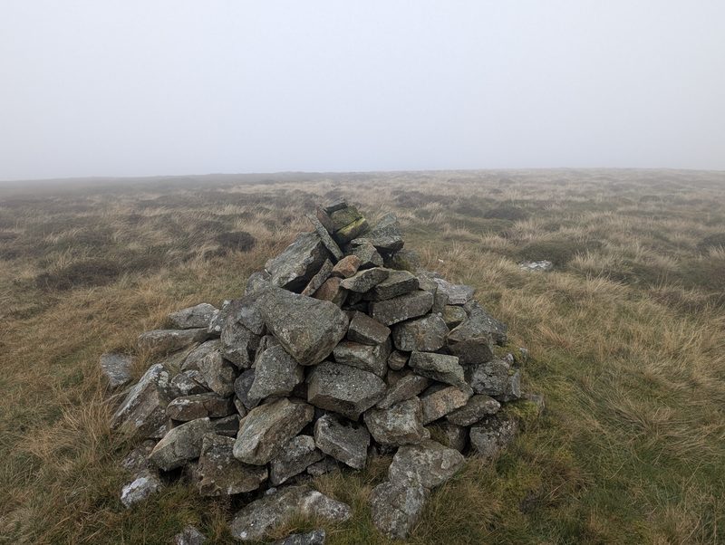 The small cairn on Miller Moss, on a wide top of grass and heather in mist