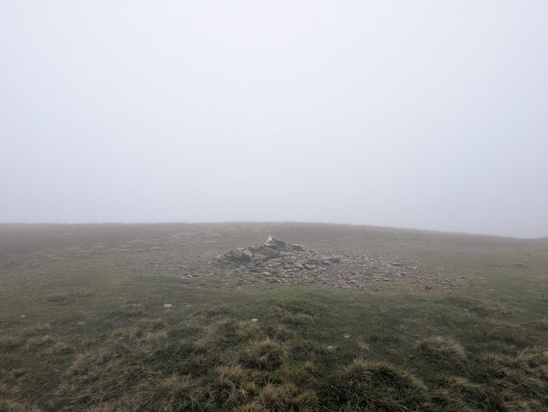 The low cairn on the broad grassy top of Knott, in mist