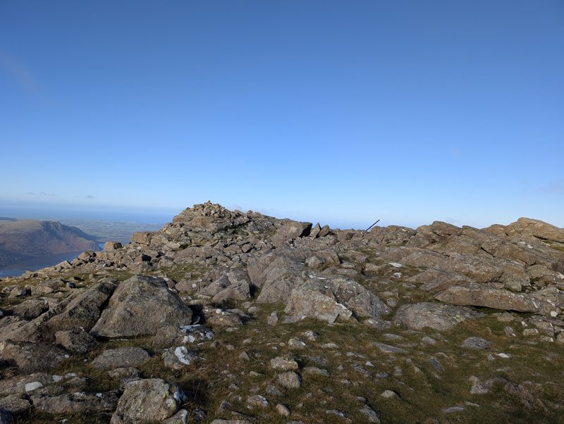 Grey boulders on the top of High Stile, a lake and low ground far below on the left